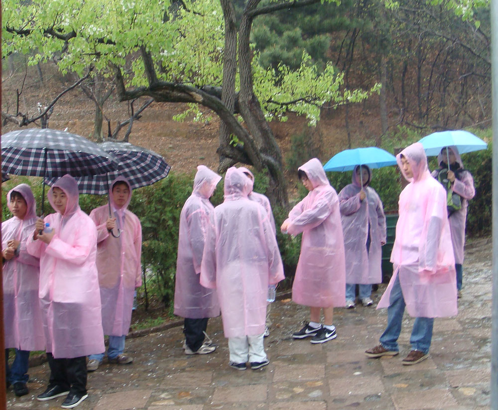 在长城脚下，大家穿好雨衣准备出发